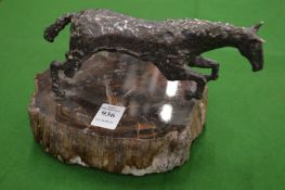 A white metal model of a rearing horse on hard stone base.
