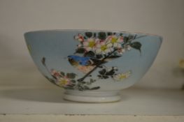 A small Japanese porcelain bowl decorated with birds on branch.