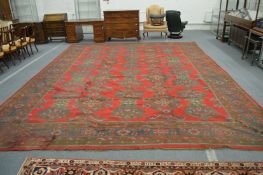 A large Turkish carpet, red ground with stylised decoration (faults), 540cm x 400cm.