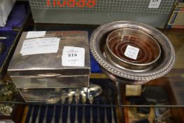 A silver cigarette box and two wine bottle coasters.