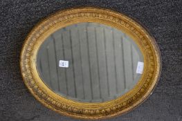 Decorative gilt framed oval wall mirror.