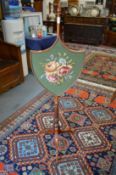 An elegant Edwardian inlaid mahogany shield shaped pole screen.