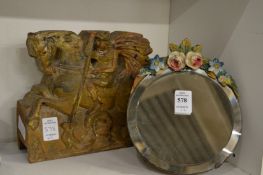 A small decorative mirror and a carved wood figure group.