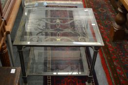 A heavy wrought iron square shaped two tier coffee table with glass top and under tier.