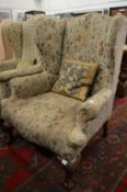 Floral upholstered Georgian style wing armchair on cabriole legs.