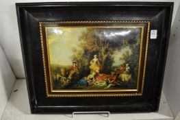 A classical style painting on metal depicting figures picnicking beneath a tree in an ebonised