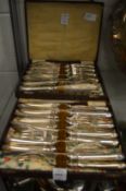 Two boxes containing a quantity of plated fish knives and forks.