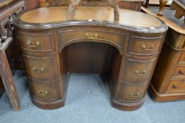A reproduction mahogany kidney shaped pedestal desk.