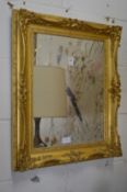 A decorative rectangular gilt framed mirror.