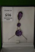 A silver and amethyst three stone drop pendant and chain.