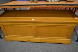 A modern light oak storage box/ottoman.