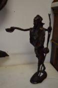 A good small cast bronze figure of a tribesman holding a bowl in his hand.