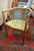 An Edwardian mahogany horseshoe shaped elbow chair.