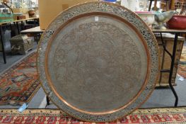A large Eastern tinned copper circular tray with engraved and pierced decoration.