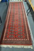 A modern Bokhara runner, 306cm x 93cm.