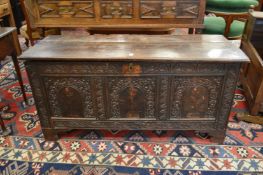 An 18th century oak coffer with plain plank top and carved triple panelled front.