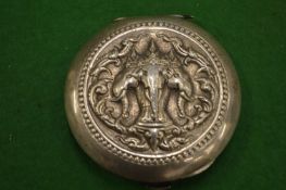 An embossed silver compact.