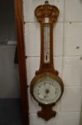 An oak barometer/thermometer.