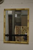 A small mirror with faux bamboo frame.