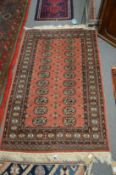 A modern pink ground Bokhara carpet, 153cm x 96cm.