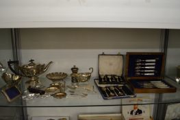A silver teapot with matching pedestal sugar bowl, silver sauce boat and other items of silverware.