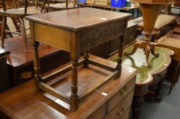 An oak stool with storage compartment.