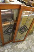 A pair of pine framed cupboards with stained glass leaded panels.