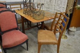 A teak drop leaf gateleg dining table and four chairs.