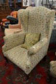 Floral upholstered Georgian style wing armchair on cabriole legs.