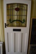 A painted external door with leaded and stained glass panel.