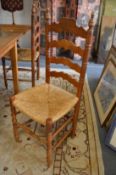A set of six pine and rush seated ladder back dining chairs.