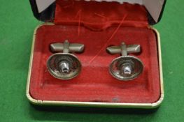 A cased pair of cufflinks in the form of Mexican hats.