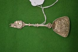 An embossed white metal spoon.