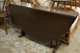 An Ercol drop leaf gateleg dining table together with a set of six chairs, one with arms.