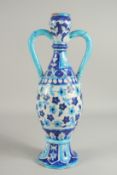 AN ISMALMIC BLUE AND WHITE GLAZED POTTERY VASE, with twin handles, 44.5cm high.