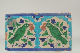 A LARGE EARLY 19TH CENTURY NORTH INDIAN MULTAN GLAZED POTTERY TILE, depicting two birds mihrab