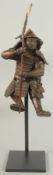 A 19TH CENTURY JAPANESE OKIMONO OF A SAMURAI, elevated on a purpose-made display stand, figure