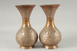 A PAIR OF MAMLUK SILVER INLAID COPPER VASES, with engraved and chased decoration, 25cm high.