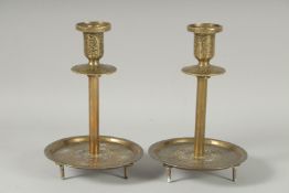 A FINE PAIR OF ISLAMIC SILVER INLAID BRASS CANDLESTICKS, 19cm high.