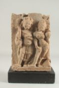 AN EARLY INDIAN CARVED STONE PANEL, with a fitted wooden base, 32cm x 22cm.