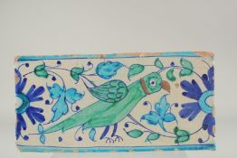 AN EARLY 19TH CENTURY NORTH INDIAN MULTAN GLAZED POTTERY TILE, painted with a parrot, 30.5cm x