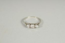 AN 18CT GOLD THREE STONE GRADUATED DIAMOND RING.