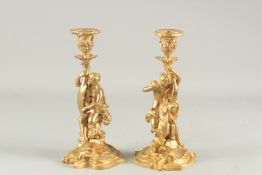 A PAIR OF CLASSICAL STYLE GILT BRONZE FIGURAL CANDLESTICKS. 11.5ins high.