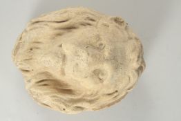 AN EARLY CARVED STONE LION'S HEAD ROUNDEL. 9ins high.
