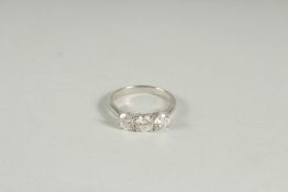 A PLATINUM AND DIAMOND THREE STONE DIAMOND RING.