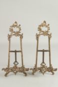 A PAIR OF DECORATIVE CAST BRASS EASELS. 1ft 4ins high.