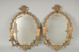 A PAIR OF METAL OVAL MIRRORS with 2 scroiting bands.