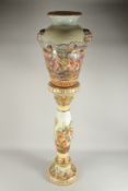 A CAPODIMONTE PORCELAIN URN ON STAND with grotesque mask handles, the vase and stand relief