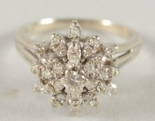A 14CT WHITE GOLD DIAMOND CLUSTER RING.