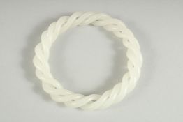 A JADE WHITE TWIST BANGLE. 3ins diameter.